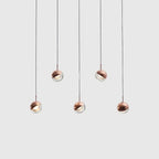 Linear glass globe pendant, five lights, in copper, staggered