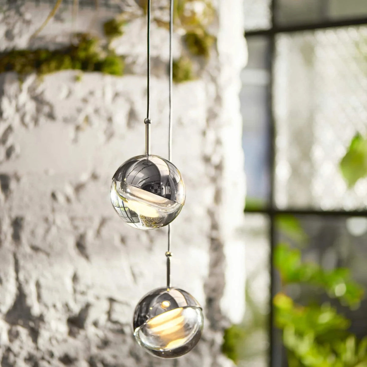 Linear glass globe pendant, five lights, close-up beside a white brick wall