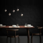 Linear glass globe pendant, five lights, above a dining table