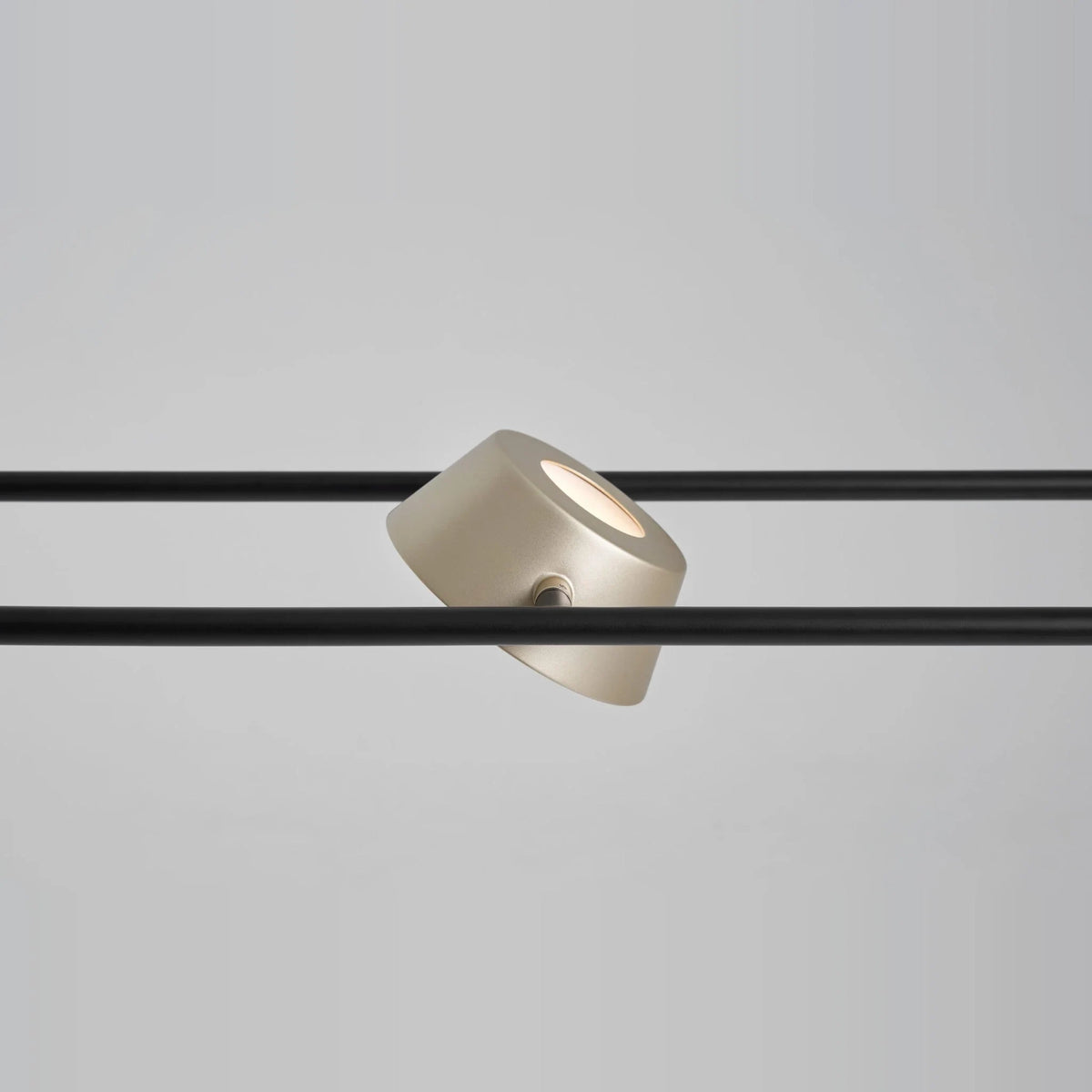 Linear LED pendant with four rotating shades, close-up of a champagne gold shade