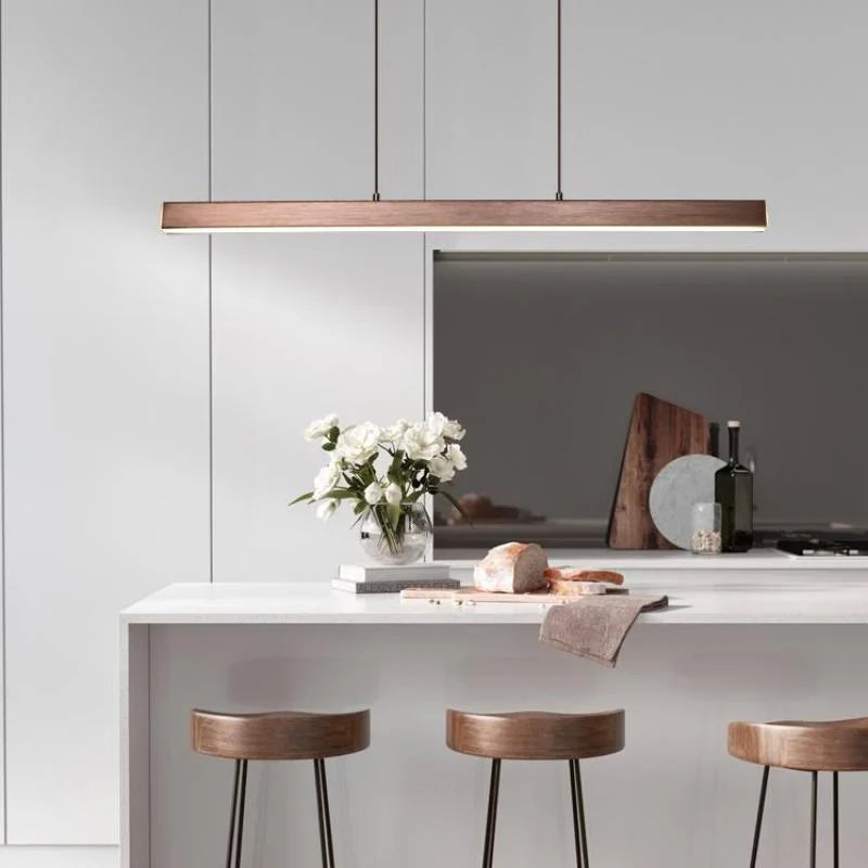 Linear LED pendant light, in brown, above a kitchen