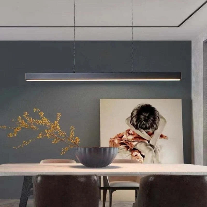 Linear LED pendant light, in black, over a dining table