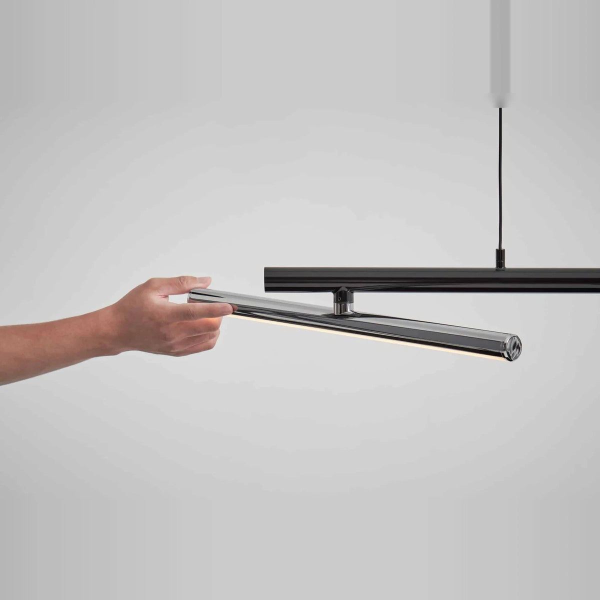 Linear LED pendant with three tilting bars, tilting a bar by hand