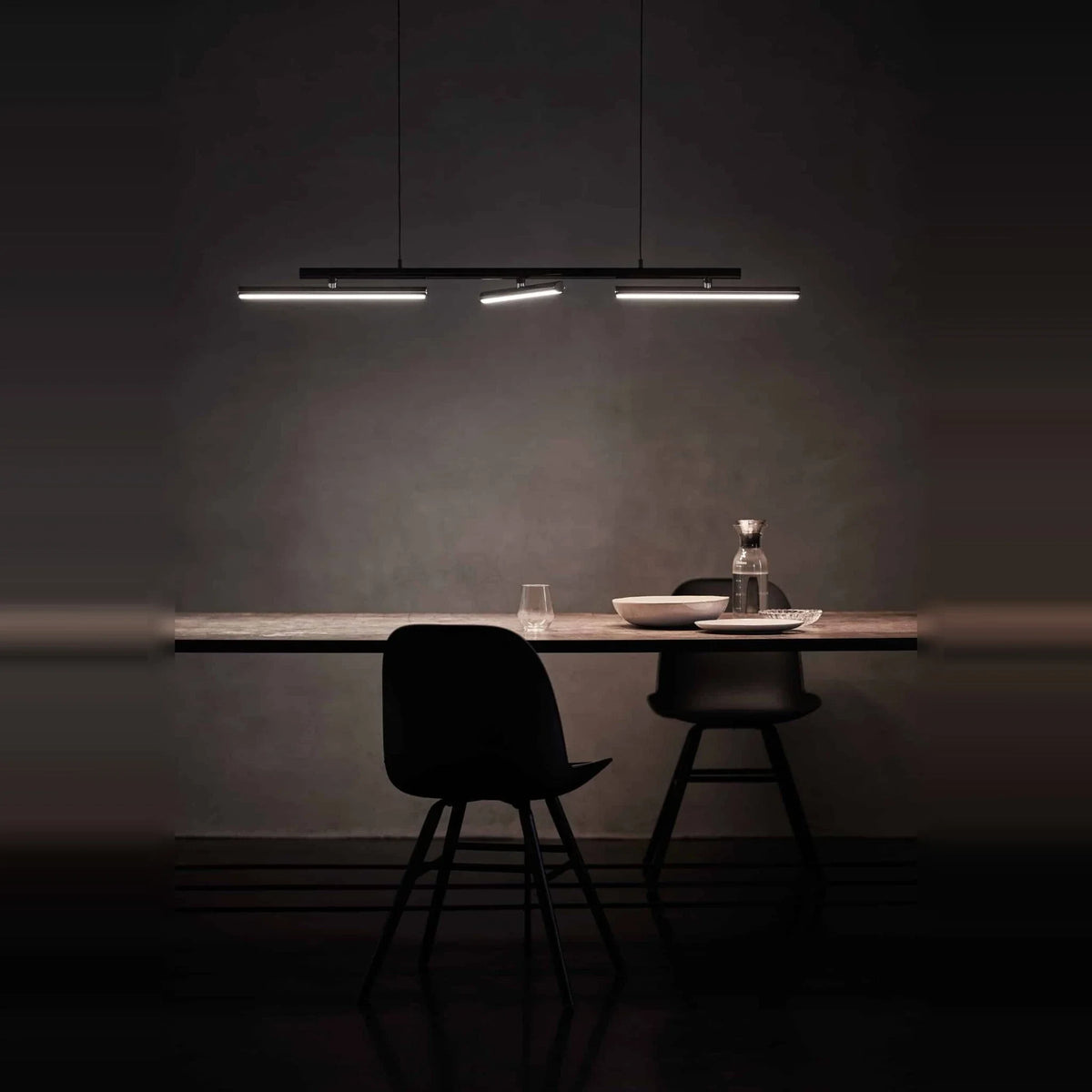 Linear LED pendant with three tilting bars, above a dining table