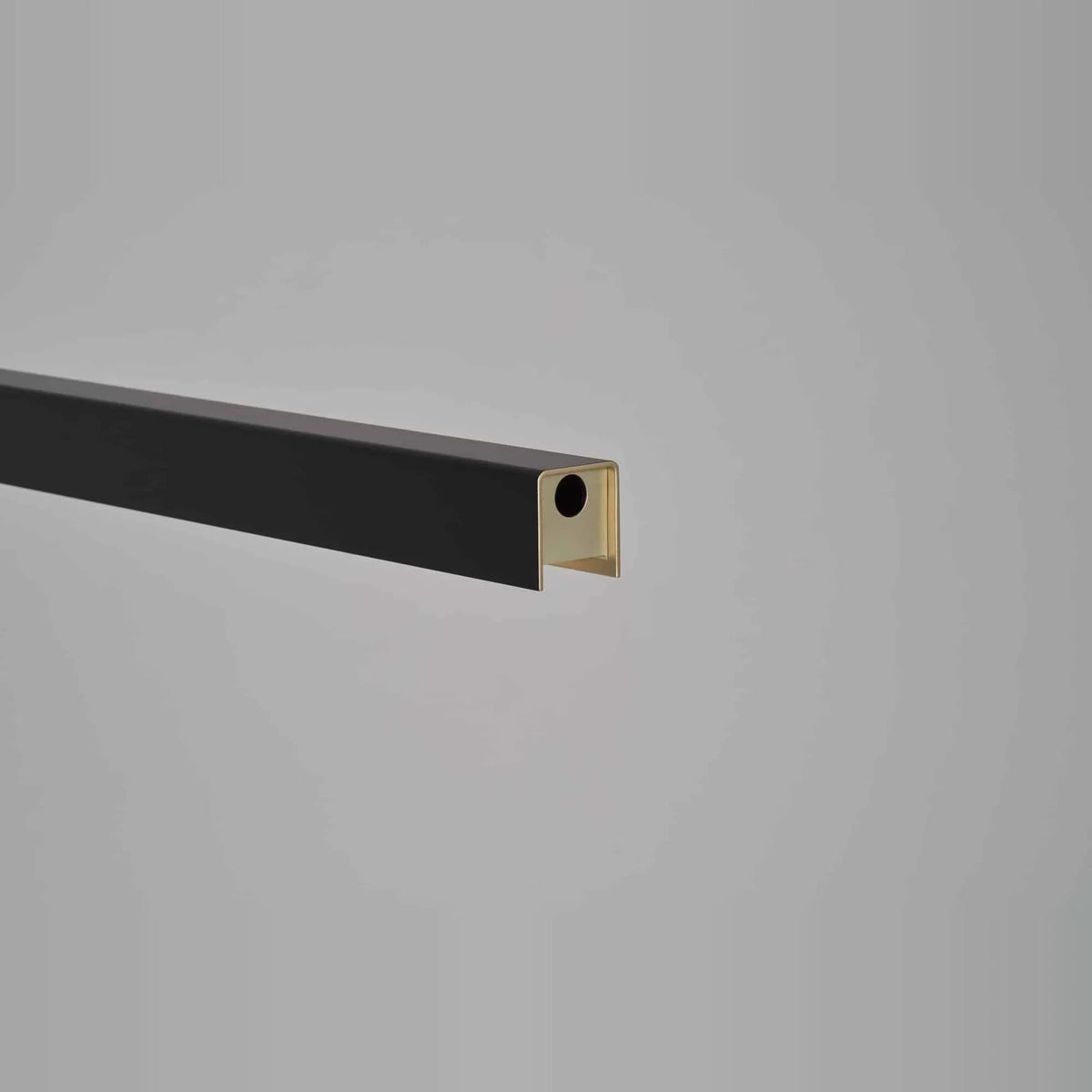 Linear LED pendant with touchless dimmer, close-up of the black end with sensor