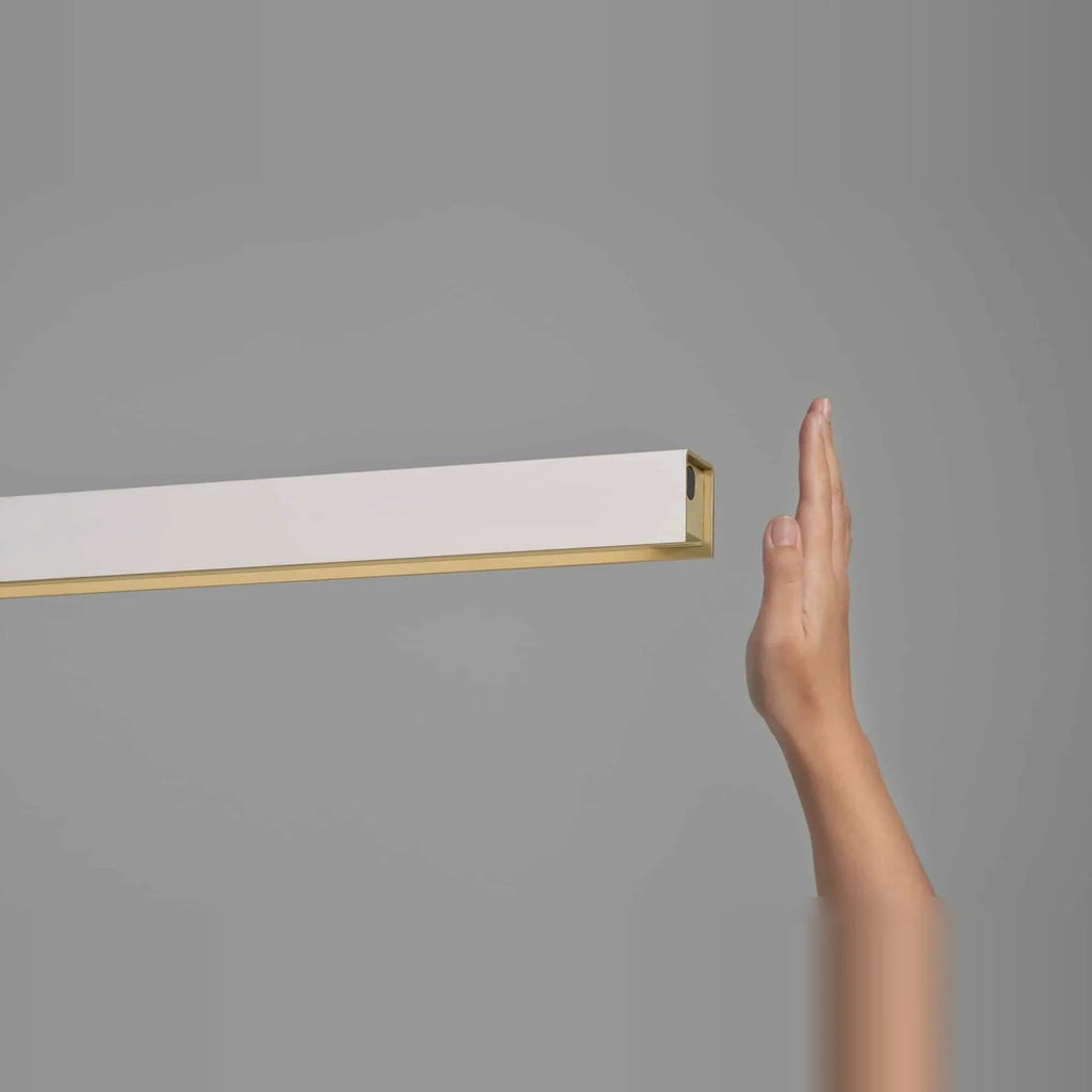 Linear LED pendant with touchless dimmer, hand at the sensor