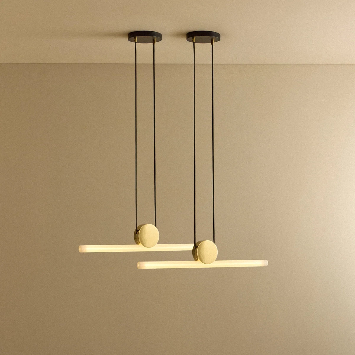 Linear LED tube pendant, set of 2, polished brass, two pendants lit and hung at different heights