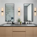 Linear LED wall light with a veined shade, either side of vanity mirrors