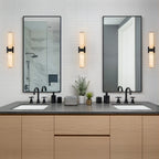 Linear LED wall light with a veined shade, either side of vanity mirrors