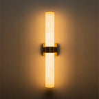 Linear LED wall light with a veined shade, in brass, lit