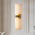 Linear LED wall light with a veined shade, in brass, on a panelled wall