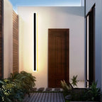 Linear outdoor wall light with a clear edge, lit on an outside wall