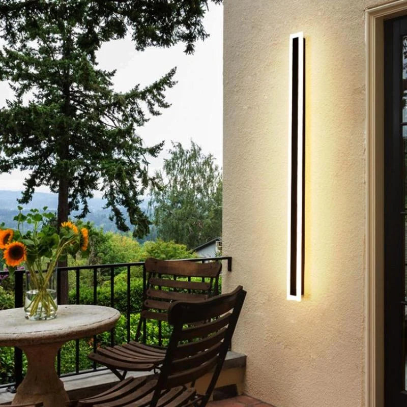 Linear outdoor wall light with a clear edge, lit on an outside wall