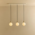 Linear triple opal globe pendant, with white canopy against a plain wall