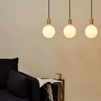 Linear triple opal globe pendant, above a sofa
