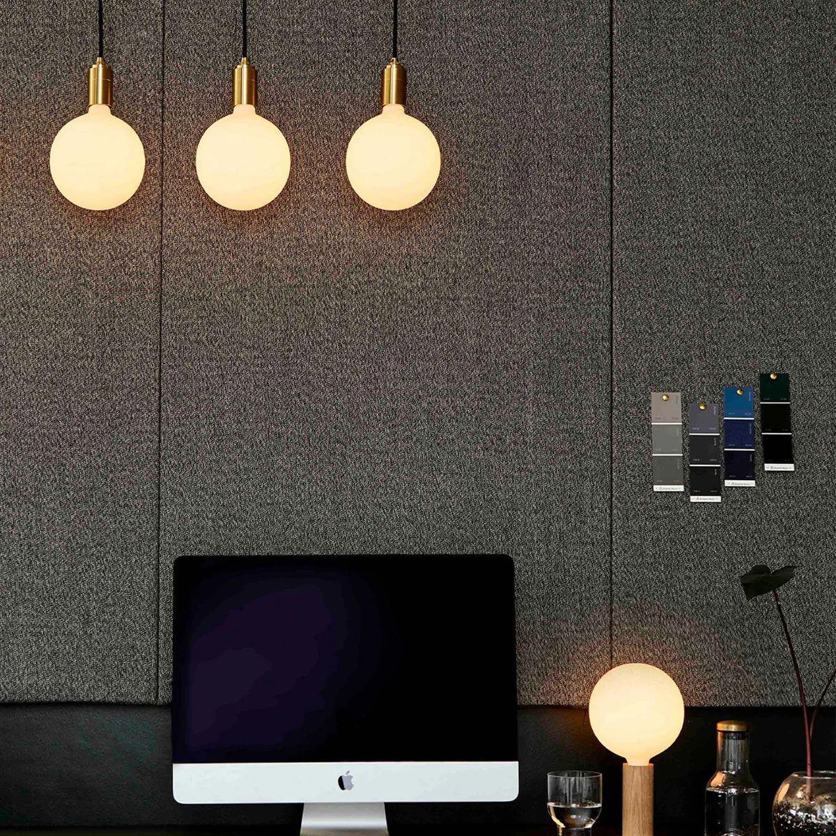 Linear triple opal globe pendant, lit above a desk