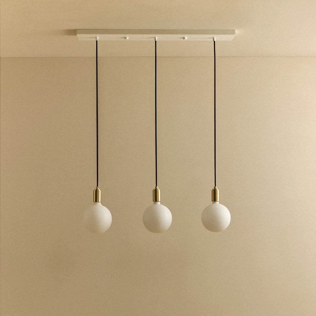 Linear triple opal globe pendant, unlit against a plain wall