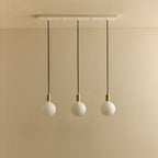 Linear triple opal globe pendant, unlit against a plain wall