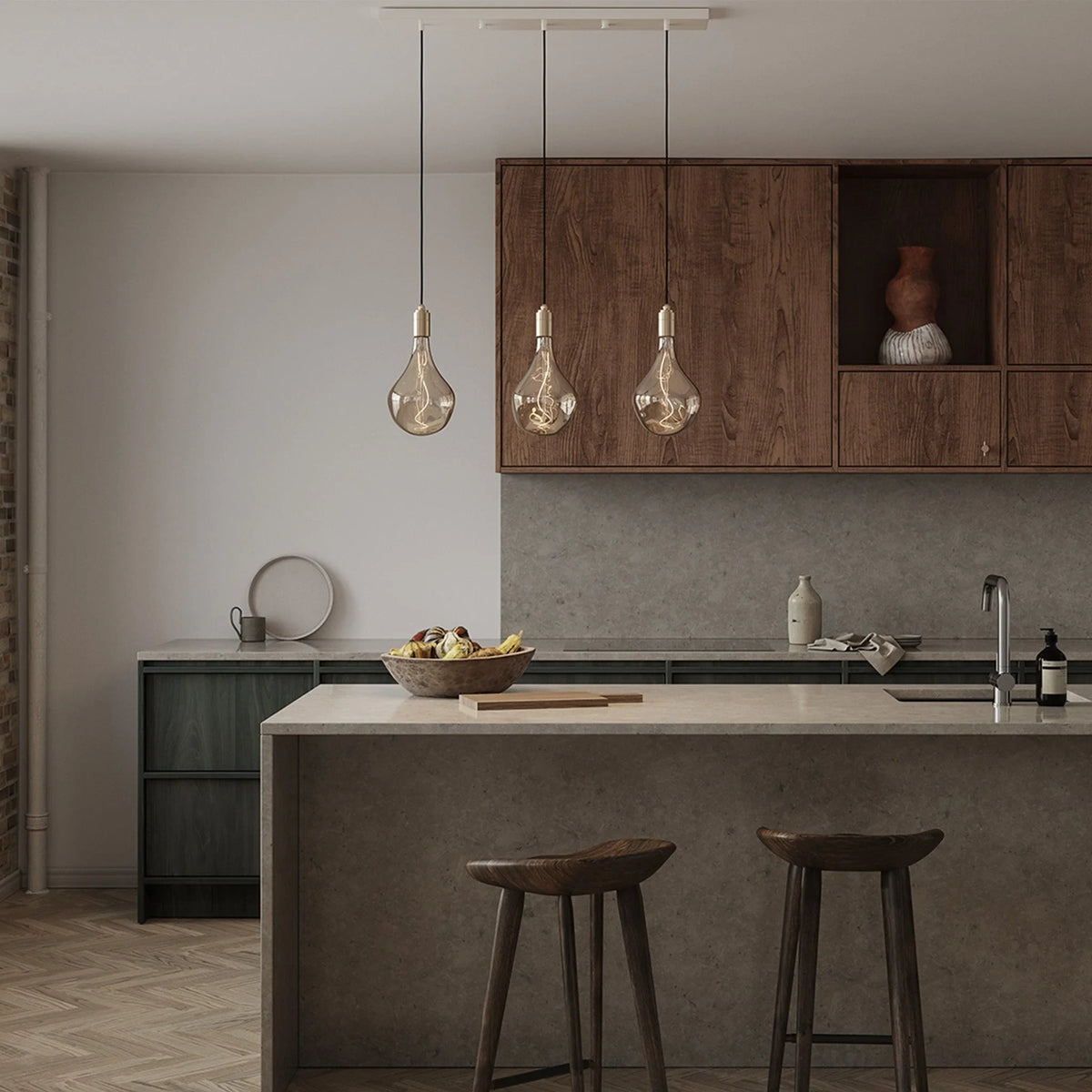 Linear triple tinted teardrop pendant, above a kitchen island with stools
