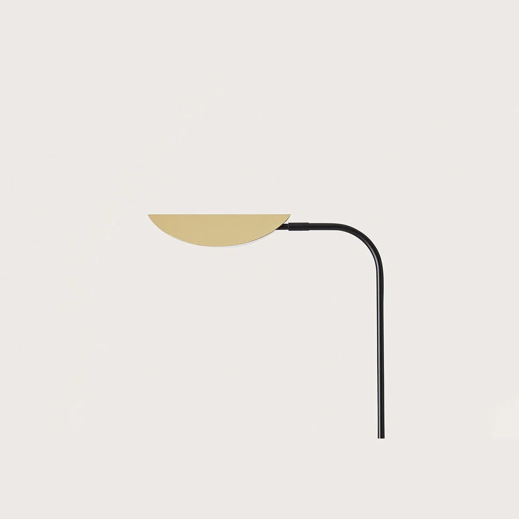Low-arc reading floor lamp with brass shade, close-up of the brass shade