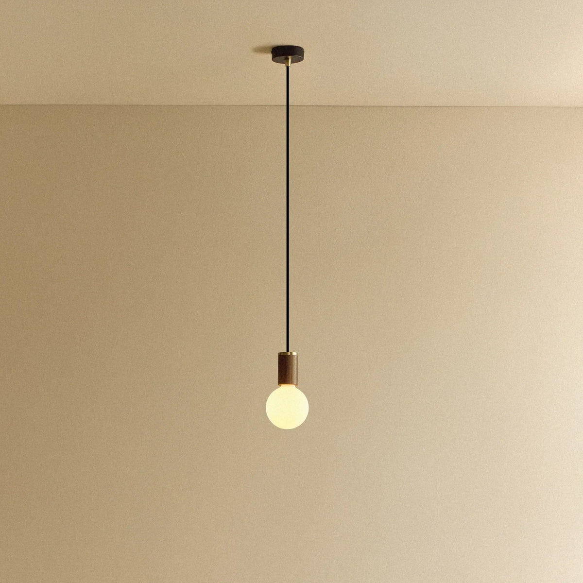 Low matte white glass pendant, mouth-blown bulb, walnut, lit, hung from the ceiling
