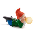 Lying dwarf table lamp with glowing glass bubble, unlit on a plain background
