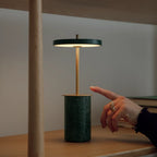 Cordless marble base table lamp, mini, green marble, hand touching the disc