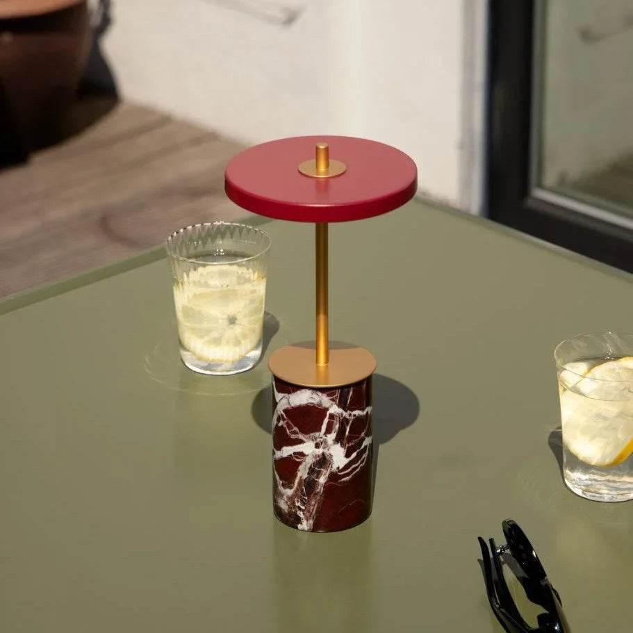Cordless marble base table lamp, mini, red marble, on a table with drinks