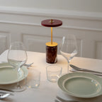 Cordless marble base table lamp, mini, red marble, lit at dinner
