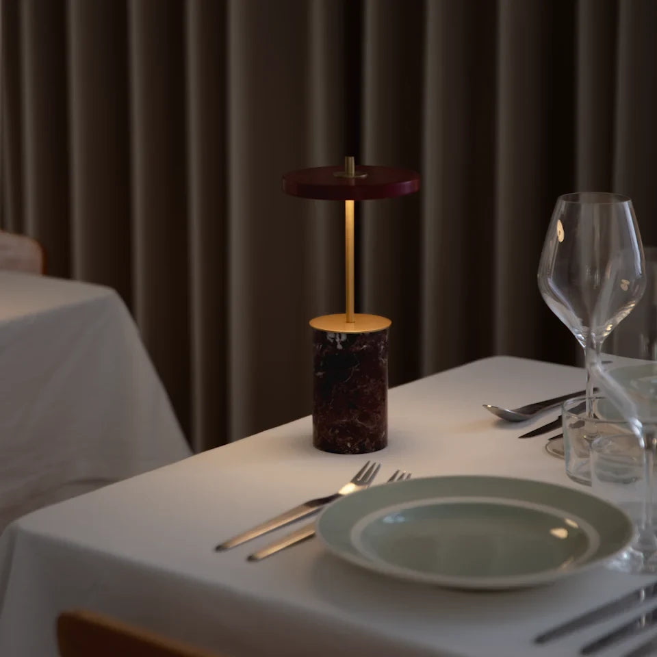 Cordless marble base table lamp, mini, red marble, lit at dinner