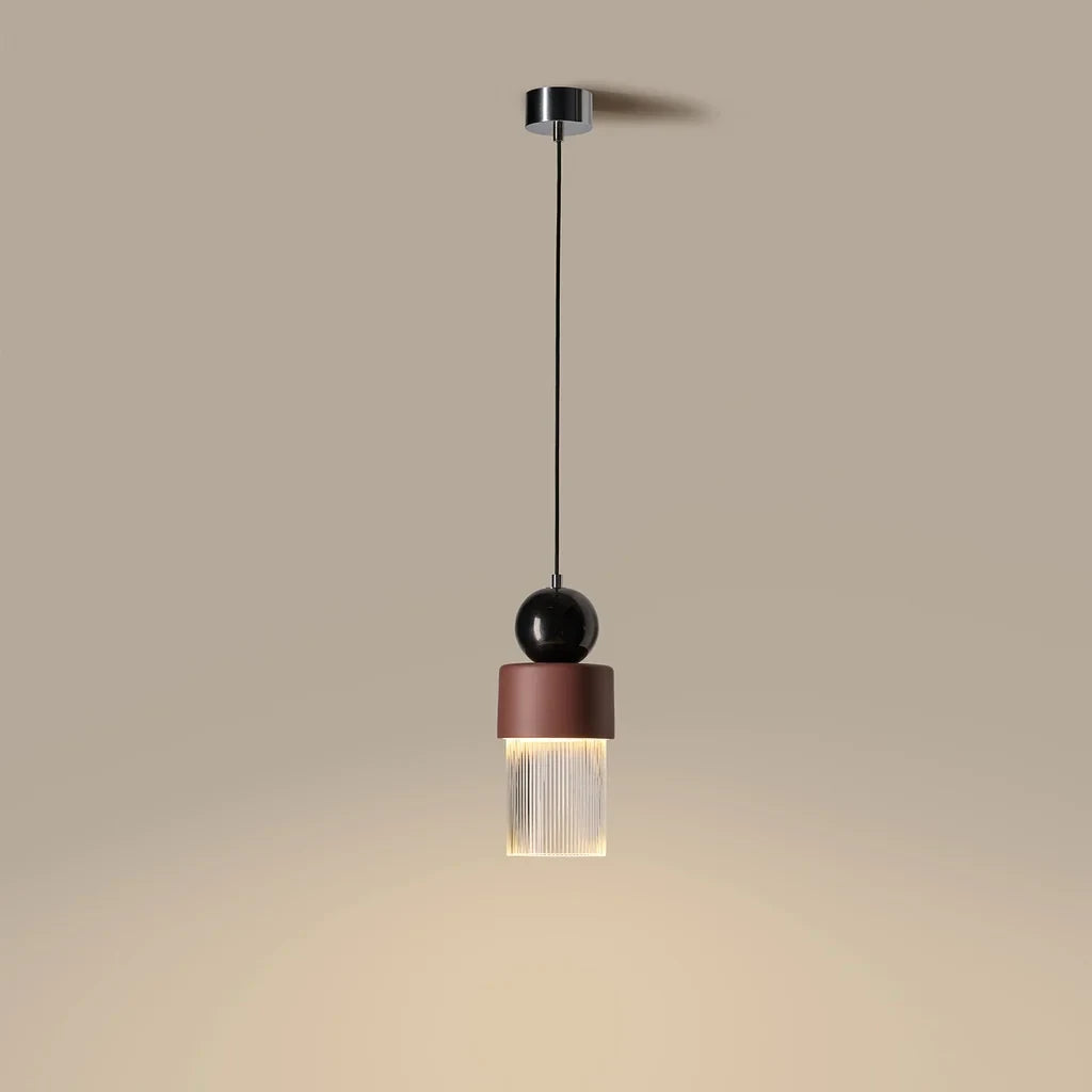 Marble, ceramic and striped glass pendant, lit, casting a warm glow