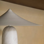Marble table lamp with a wide pointed shade, close-up of the shade and marble base