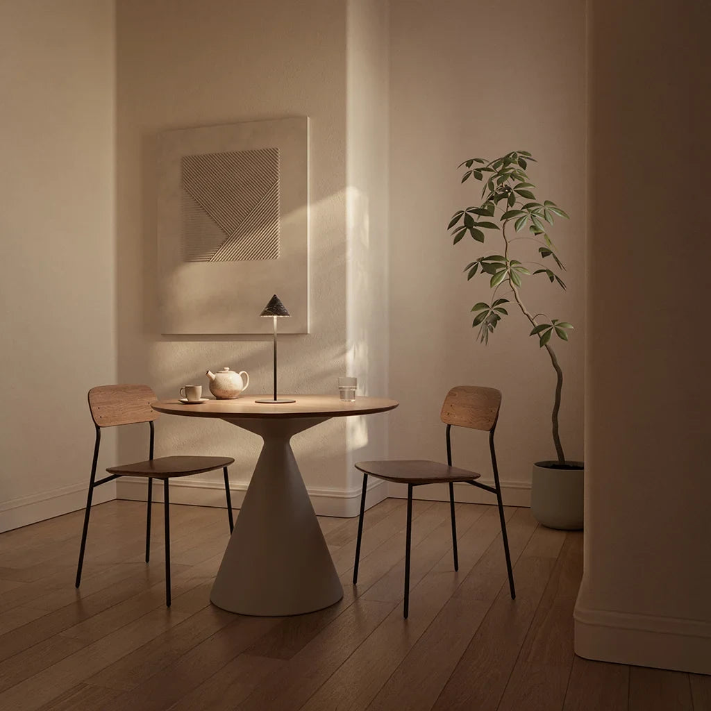 Marble cone shade LED table lamp, in matte black beside two chairs in a softly lit dining room