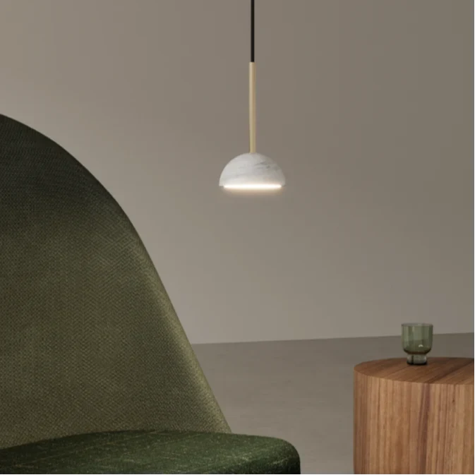 Marble dome pendant, lit beside a green armchair