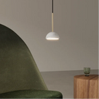 Marble dome pendant, lit beside a green armchair