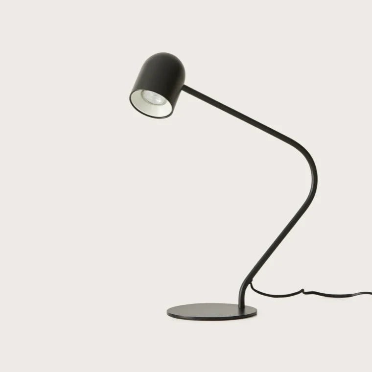 Matte black curved-arm spot desk lamp, side view