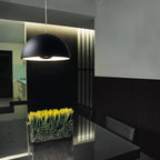 Metal dome pendant, in black above a dining table