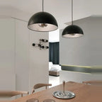 Metal dome pendant, in black above a dining table