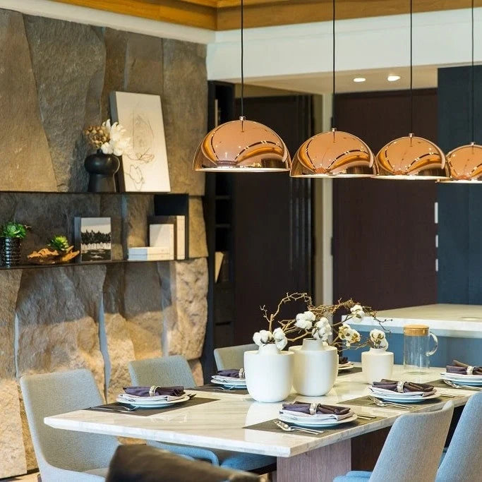 Metal dome pendant, row in copper above a dining table