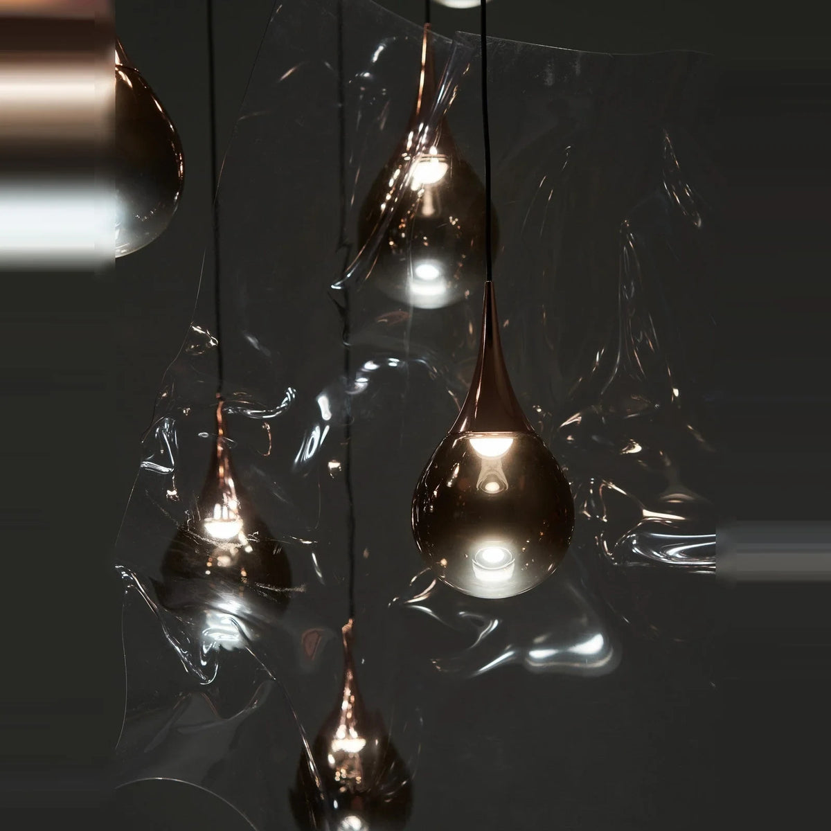 Mirrored Teardrop Five-Light Linear Pendant, close-up of shades in a dark setting