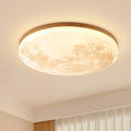 Moon flush ceiling light with a wood-effect rim, lit in a bedroom