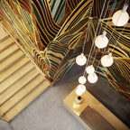 Nine-drop cluster pendant with opal globe bulbs, chalk, seen from above a staircase