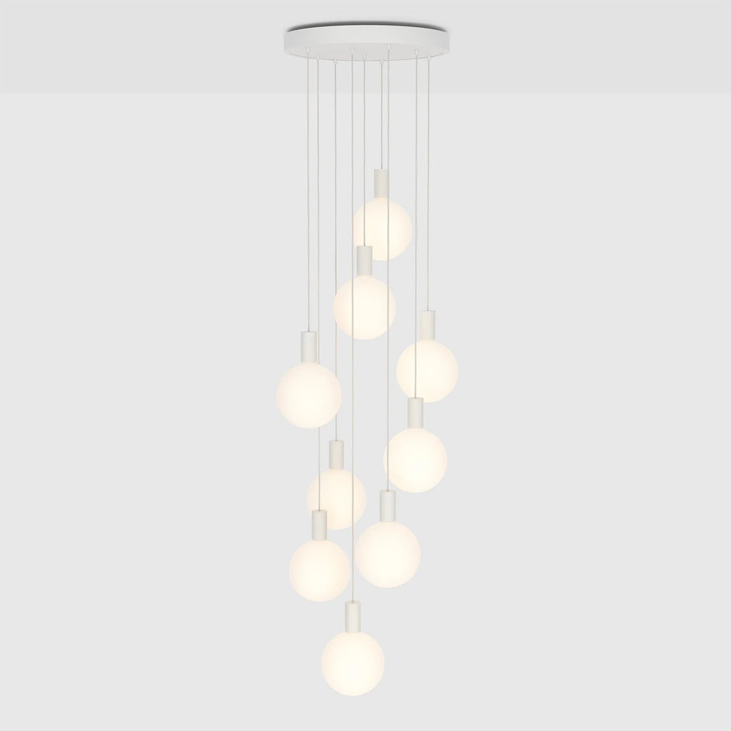 Nine-drop cluster pendant with opal globe bulbs, chalk, lit, on a plain background