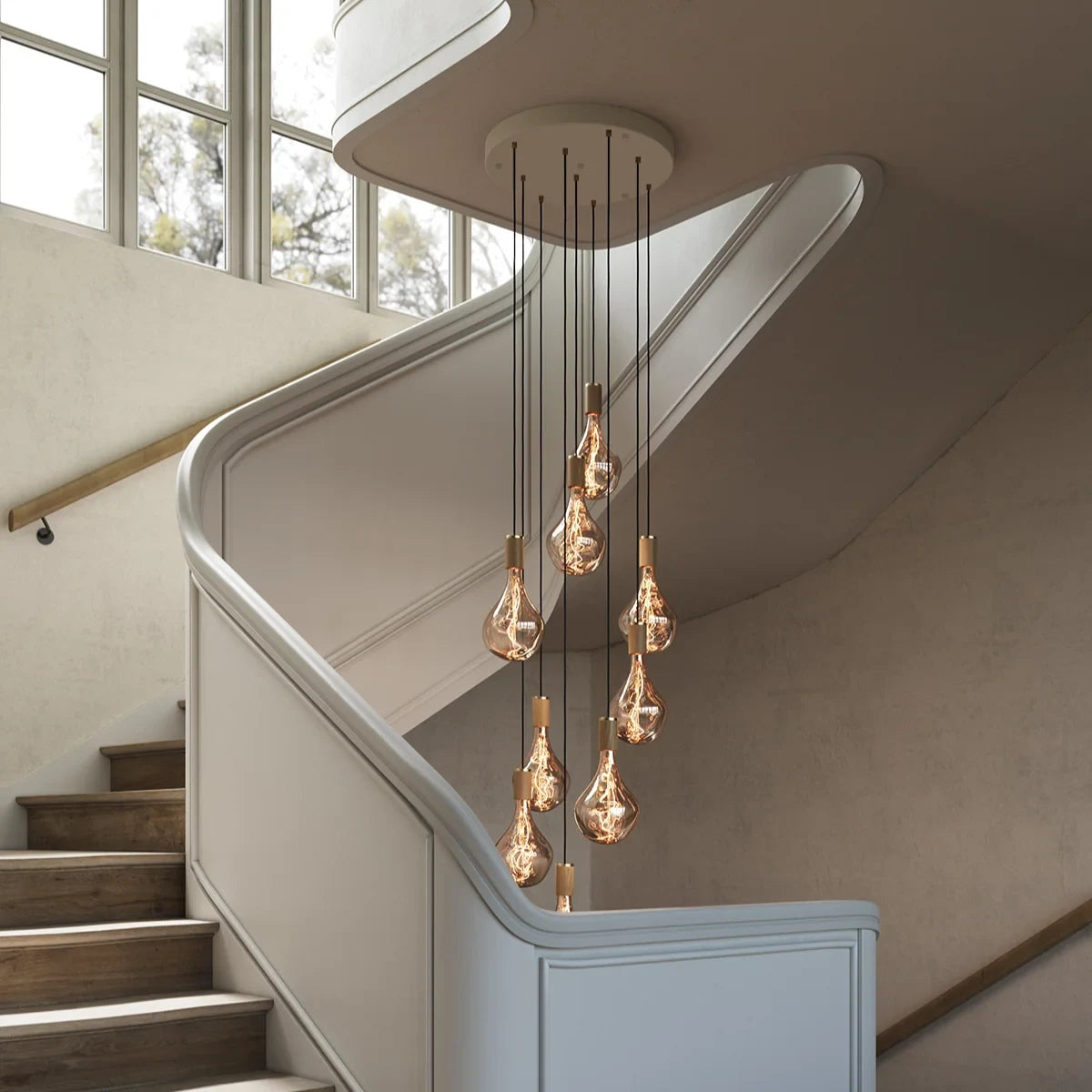 Nine-drop cluster pendant, oak, in a stairwell with tinted bulbs fitted