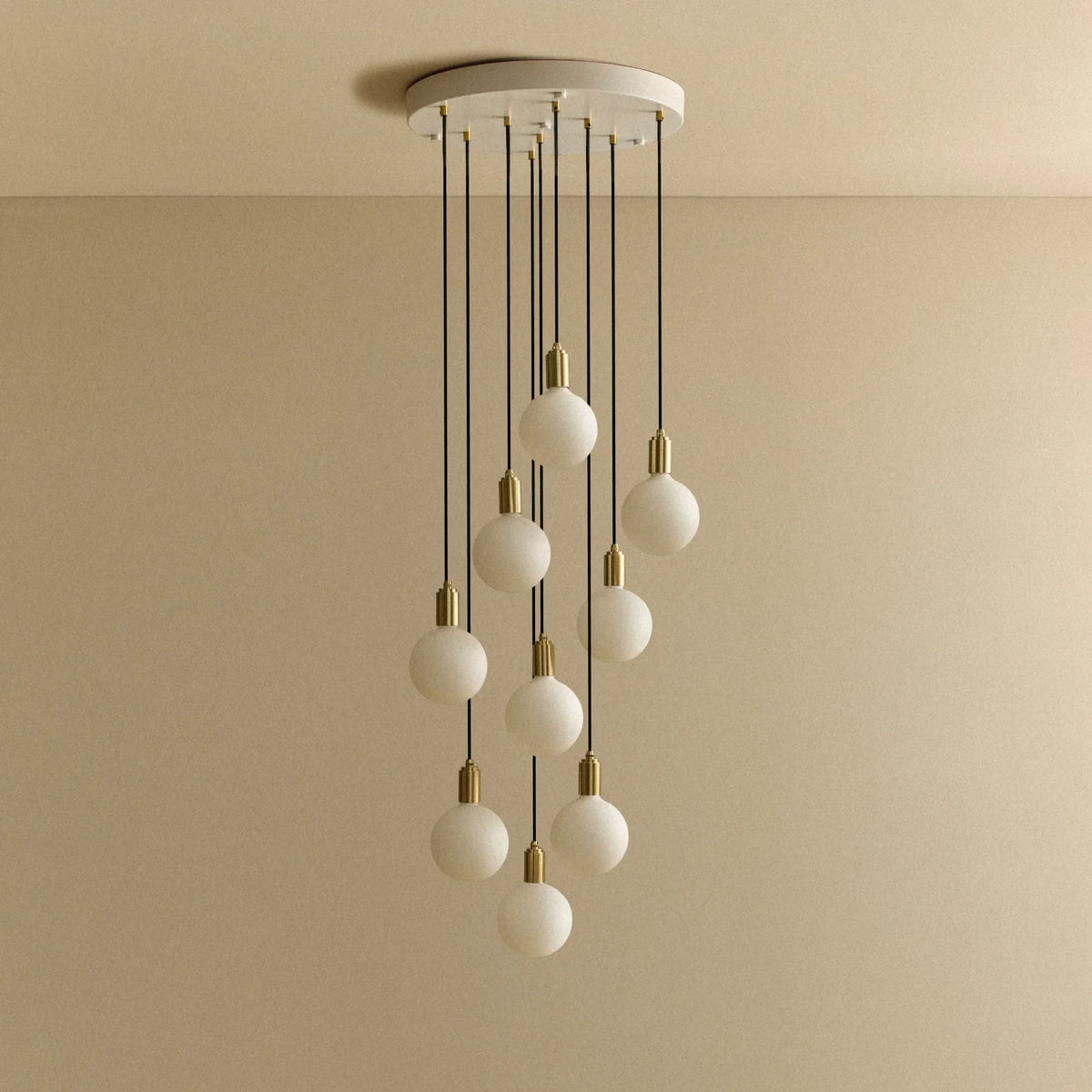 Nine-light opal globe cluster pendant, unlit against a plain wall