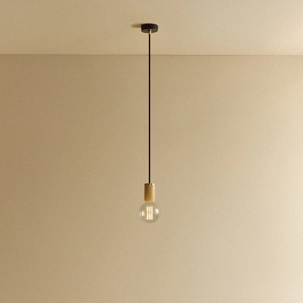 Oak cylinder pendant with filament LED bulb, against a plain wall