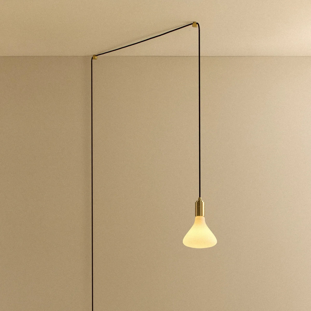 Opal cone bulb plug-in pendant, routed across the ceiling and down the wall