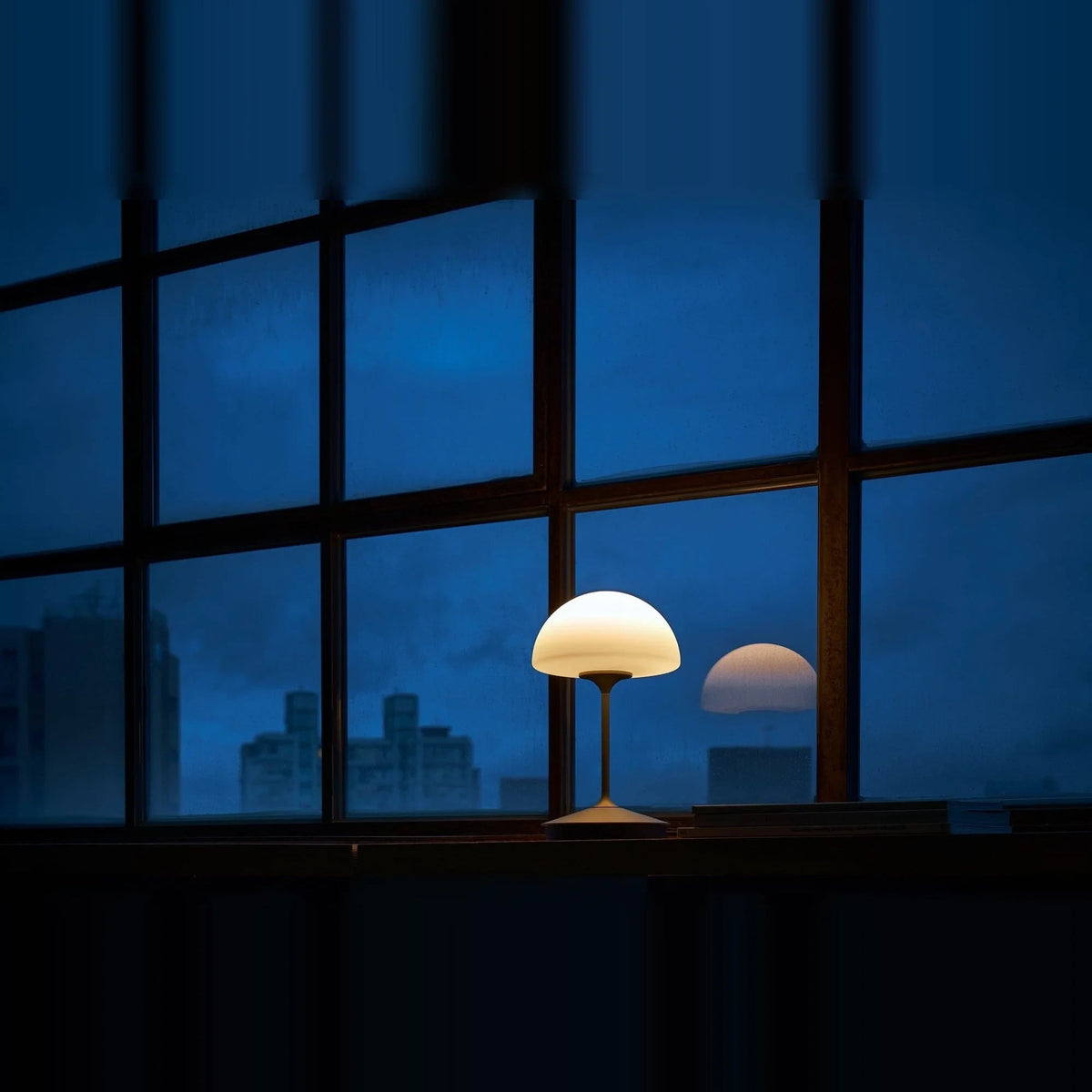 Opal glass dome table lamp with dimmer, lit on a windowsill at night