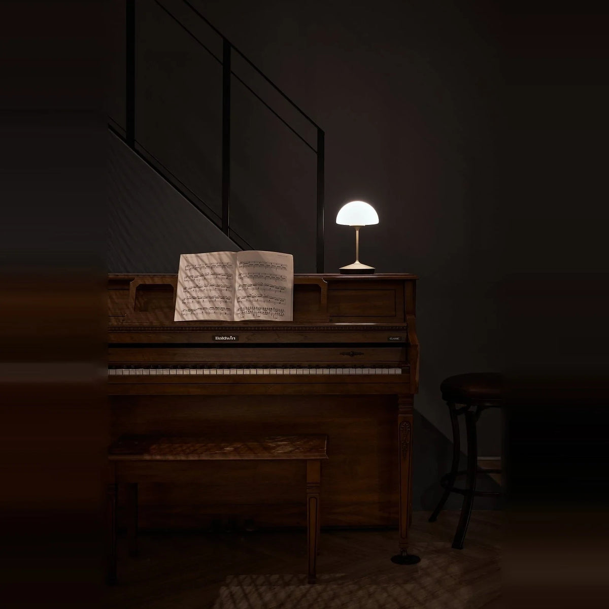 Opal glass dome table lamp with dimmer, lit on a piano in a dark room