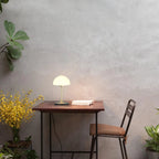 Opal glass dome table lamp with dimmer, lit on a small desk